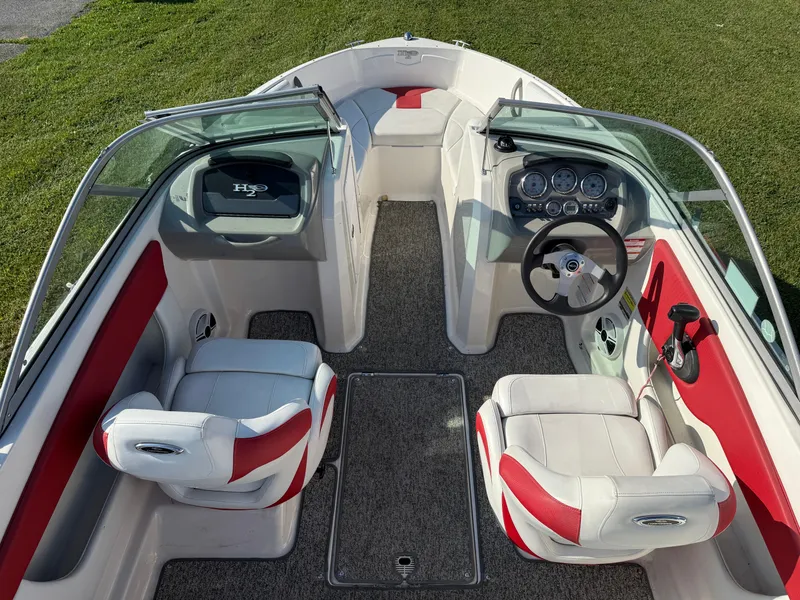 Slide: The Image of 2015 Chaparral 18 H2O Sport boat interior with red and white seating, dashboard, and steering wheel. - 6