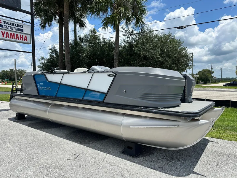Slide: The Image of 2026 Sylvan A22 LZ Sport pontoon boat displayed outdoors under a sunny sky. - 1