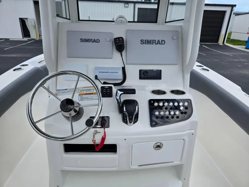 Slide: The Image of 2023 NauticStar 242L Offshore boat console with steering wheel and Simrad electronics. - 10