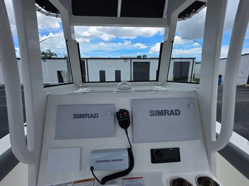 Slide: The Image of 2023 NauticStar 242L Offshore boat dashboard with Simrad electronics and radio. - 14