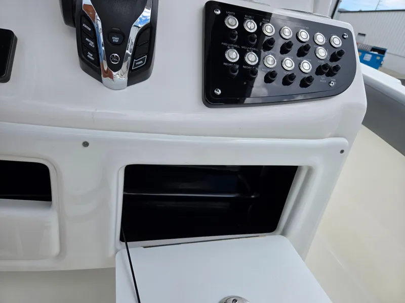 Slide: The Image of Control panel of 2023 NauticStar 242L Offshore boat with open storage compartment. - 16