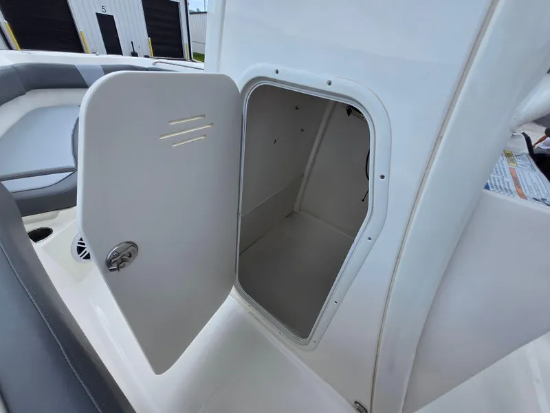 Slide: The Image of 2023 NauticStar 242L Offshore boat storage compartment with open door. - 18