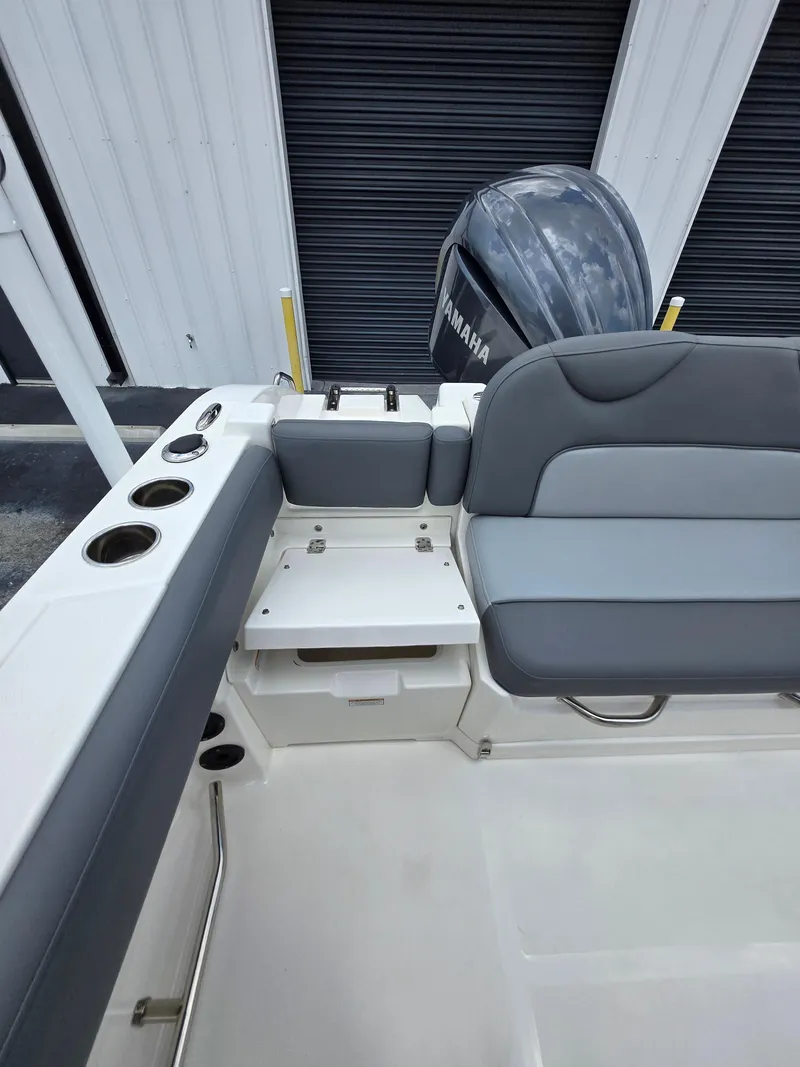 Slide: The Image of 2023 NauticStar 242L Offshore boat interior with Yamaha engine, featuring seating and storage. - 20