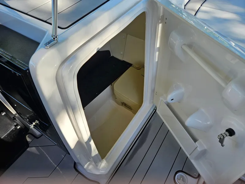 Slide: The Image of 2020 Yamaha Boats 242X interior storage compartment with open door. - 12