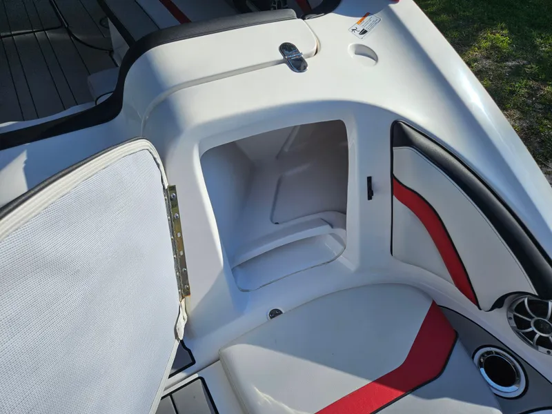 Slide: The Image of Open storage compartment on a 2020 Yamaha Boats 242X, featuring white and red interior. - 15