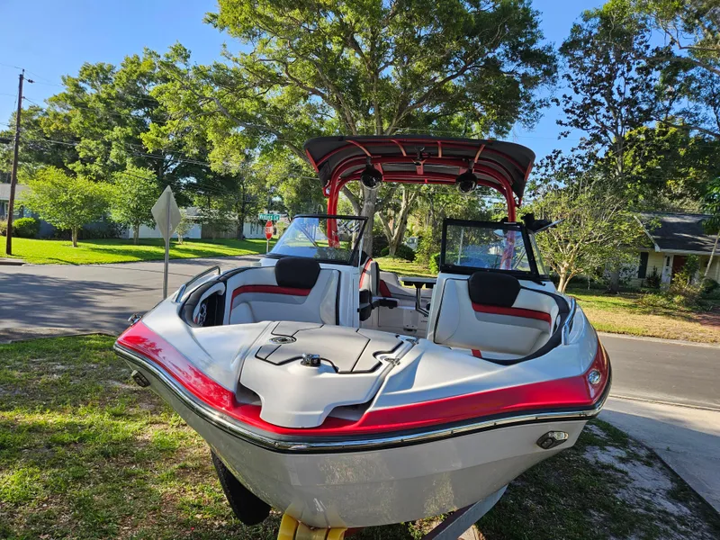 Slide: The Image of 2020 Yamaha Boats 242X in a residential area, showcasing sleek design and spacious seating. - 2