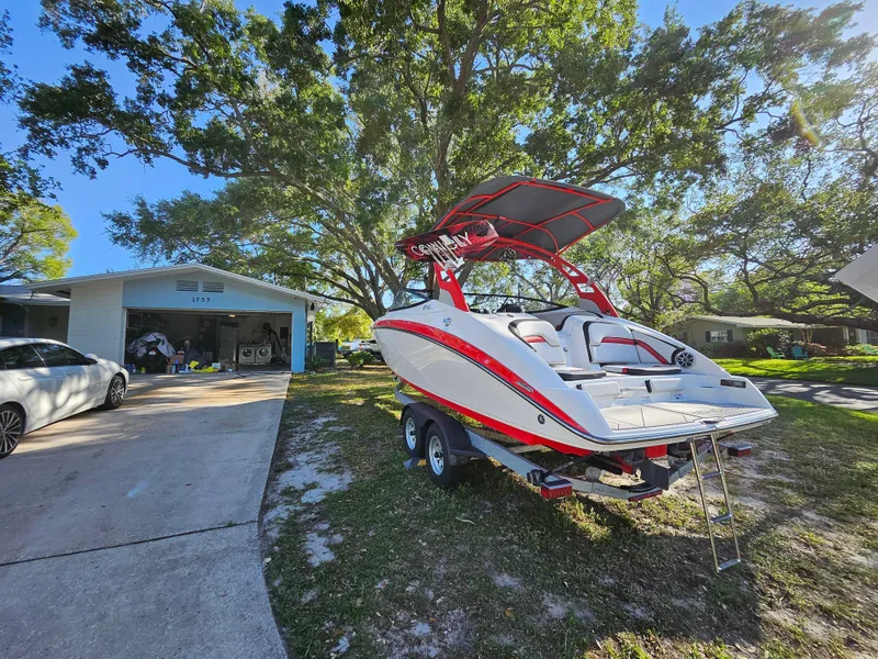 Slide: The Image of 2020 Yamaha Boats 242X parked in a driveway near a house and garage. - 25