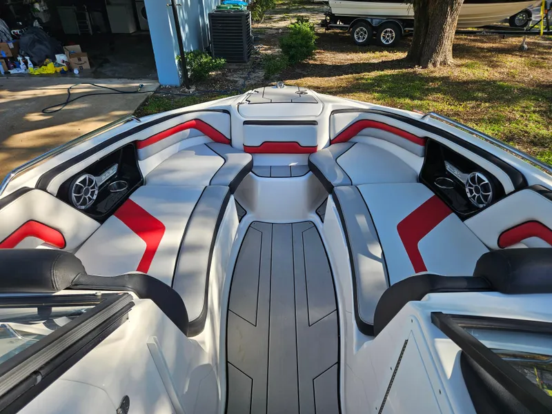 Slide: The Image of 2020 Yamaha Boats 242X interior with red and gray seating, speakers, and sleek design. - 4
