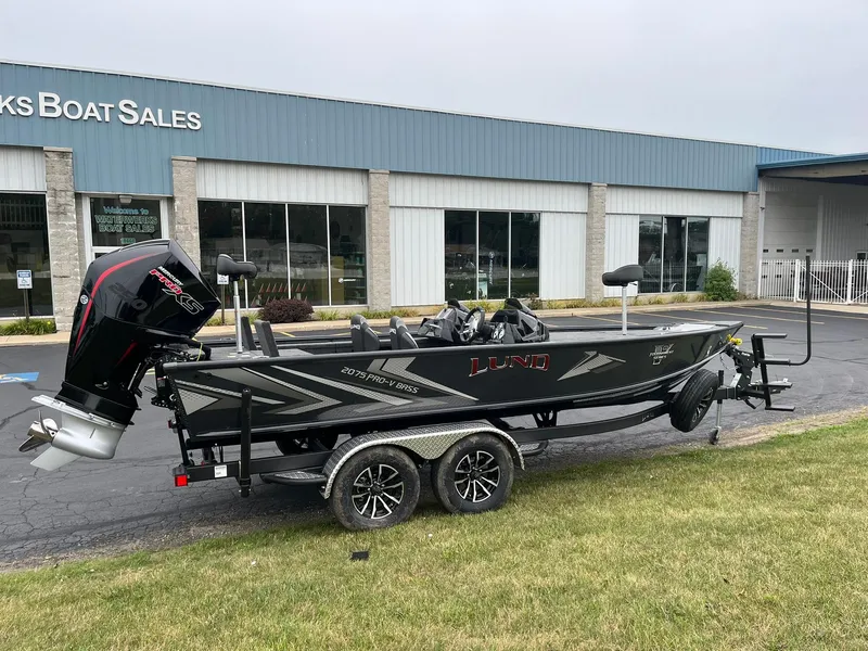 The Image of 2026 Lund 2075 Pro-V Bass XS boat on trailer outside dealership. - 0