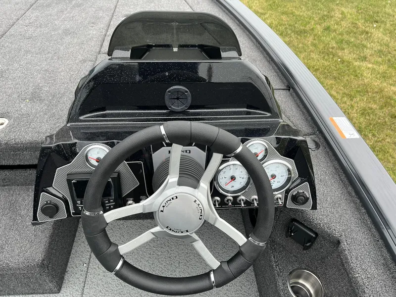 Slide: The Image of 2026 Lund 2075 Pro-V Bass XS boat dashboard with steering wheel and gauges. - 15