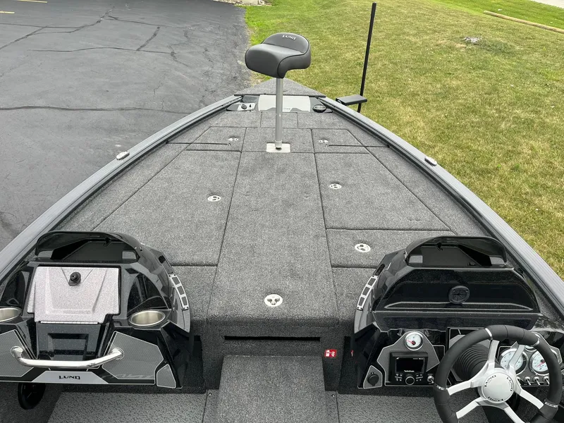 Slide: The Image of 2026 Lund 2075 Pro-V Bass XS boat interior with steering wheel and seating. - 19