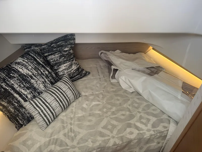 Slide: The Image of Cozy cabin interior of 2023 Tiara Yachts 34 LS with patterned bedding and pillows. - 9