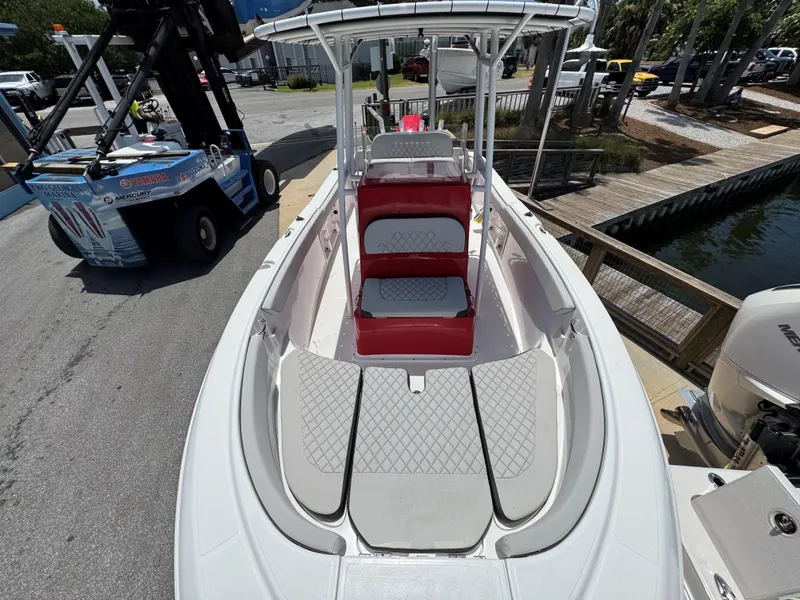 Slide: The Image of 2023 Clearwater 2200 boat with red seating and spacious deck, docked near water. - 11