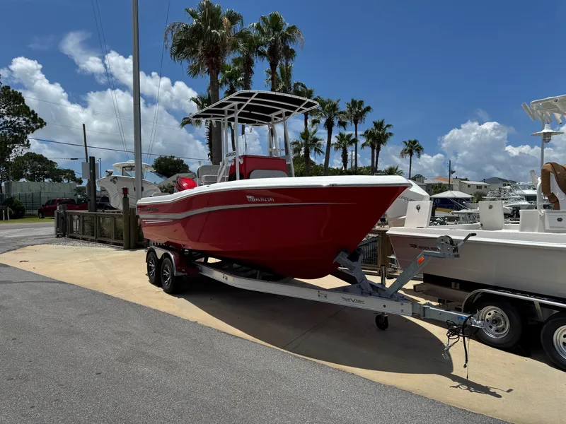 Slide: The Image of Red 2023 Clearwater 2200 boat on trailer, parked near palm trees under a clear blue sky. - 4