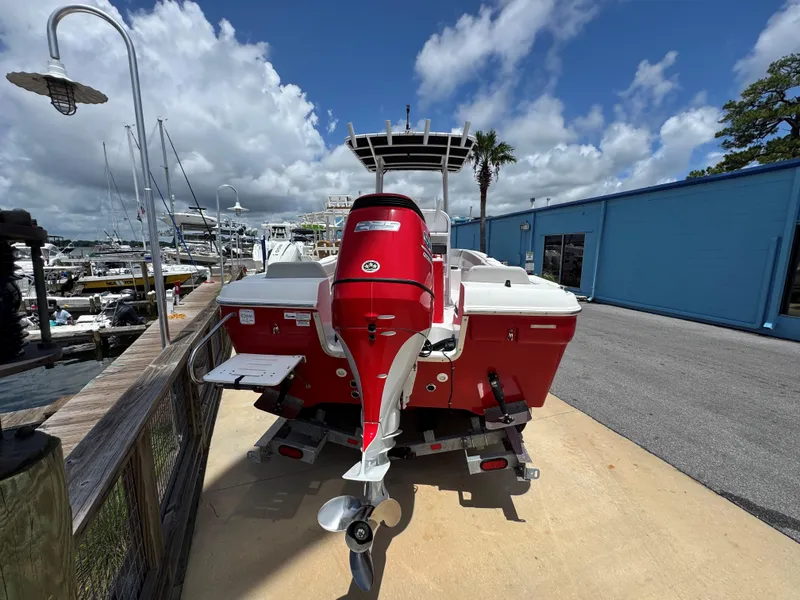 Slide: The Image of Red 2023 Clearwater 2200 boat docked at marina under blue sky. - 5