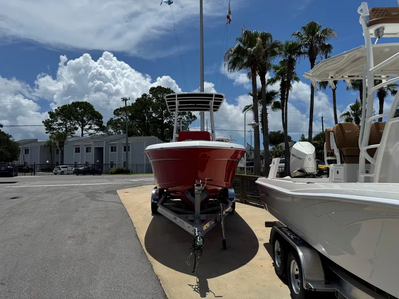 Slide: The Image of 2023 Clearwater 2200 boat on trailer, parked outdoors under a partly cloudy sky. - 6