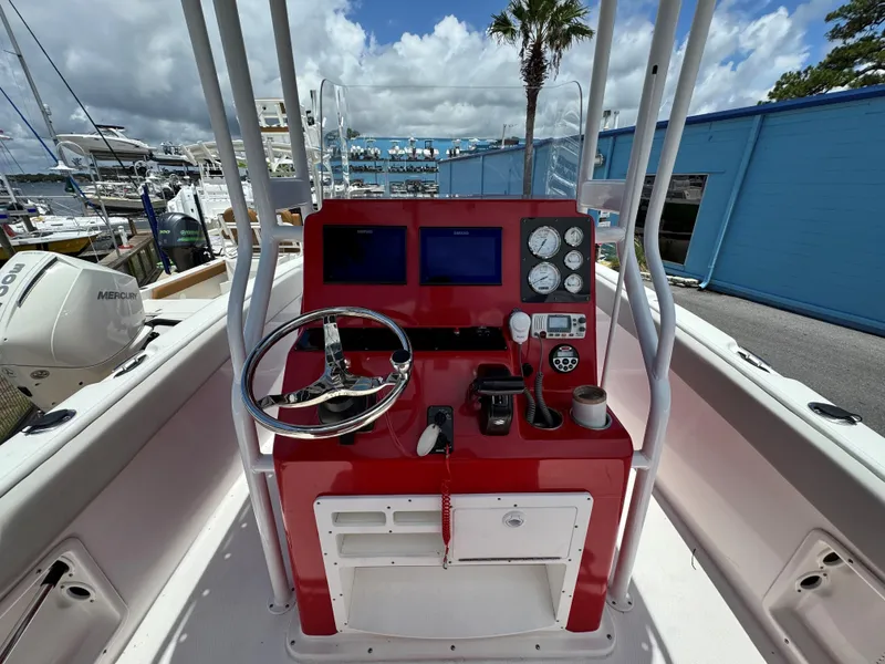 Slide: The Image of 2023 Clearwater 2200 boat dashboard with red console, steering wheel, and gauges. - 8