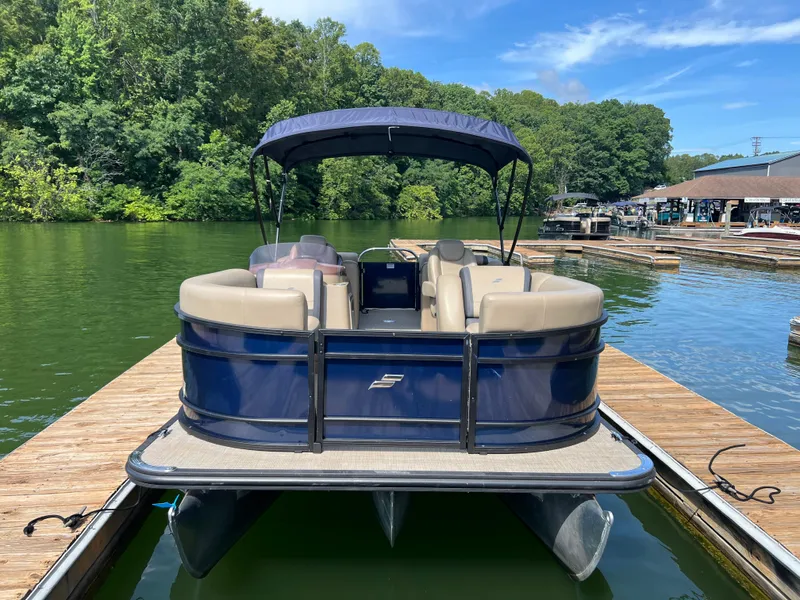 Slide: The Image of 2025 Starcraft EXS 3 pontoon boat docked on a serene lake. - 1