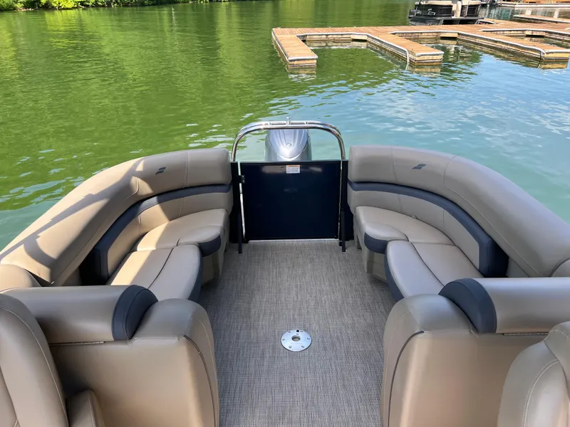 Slide: The Image of 2025 Starcraft EXS 3 pontoon boat interior with plush seating on a serene lake. - 14