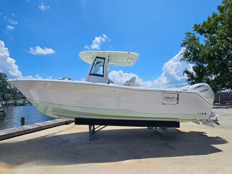 Slide: The Image of 2026 Sea Hunt Ultra 275 SE boat on display under a clear blue sky. - 1
