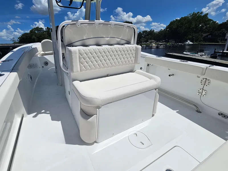 Slide: The Image of 2026 Sea Hunt Ultra 275 SE boat interior with white cushioned seating under a clear blue sky. - 14