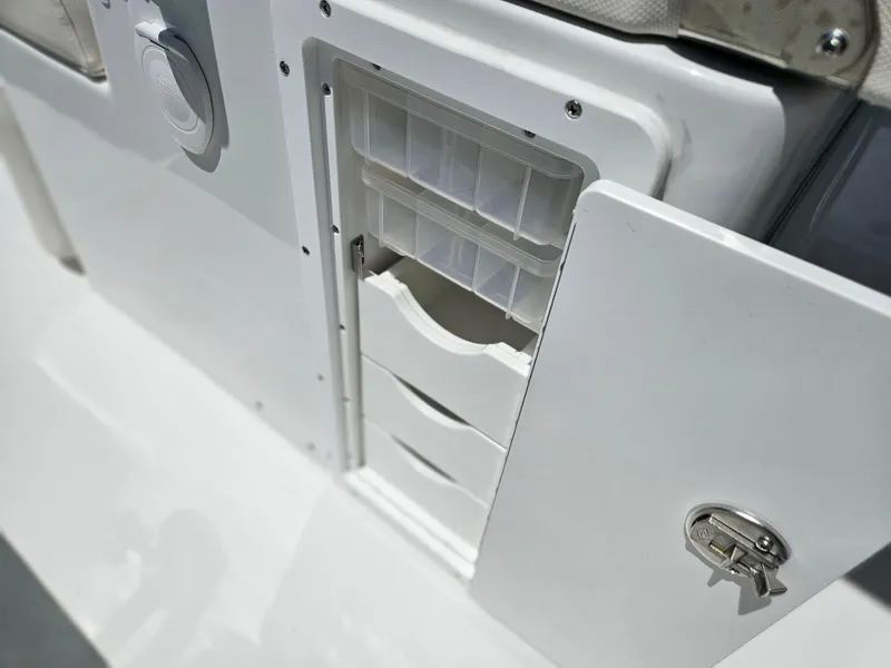 Slide: The Image of Storage compartment on 2026 Sea Hunt Ultra 275 SE boat, featuring secure lock and organized drawers. - 18