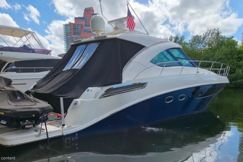 Slide: The Image of 2014 Sea Ray 470 Sundancer yacht docked, featuring sleek design and modern amenities. - 2