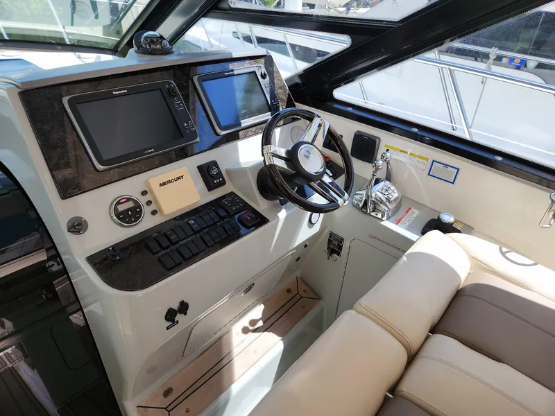Slide: The Image of 2014 Sea Ray 470 Sundancer helm with modern controls and navigation screens. - 28
