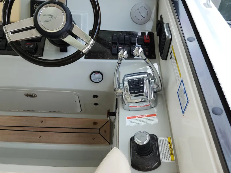 Slide: The Image of Control panel of a 2014 Sea Ray 470 Sundancer boat with steering wheel and throttle controls. - 32