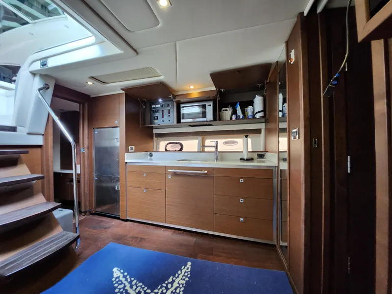 Slide: The Image of 2014 Sea Ray 470 Sundancer interior kitchen with wooden cabinets and modern appliances. - 35