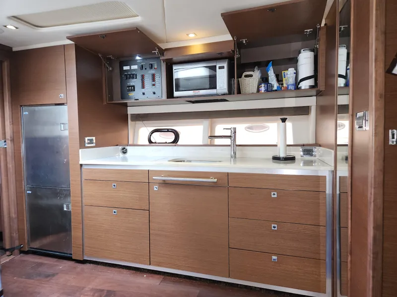 Slide: The Image of Modern kitchen interior of 2014 Sea Ray 470 Sundancer yacht with wood cabinetry. - 36