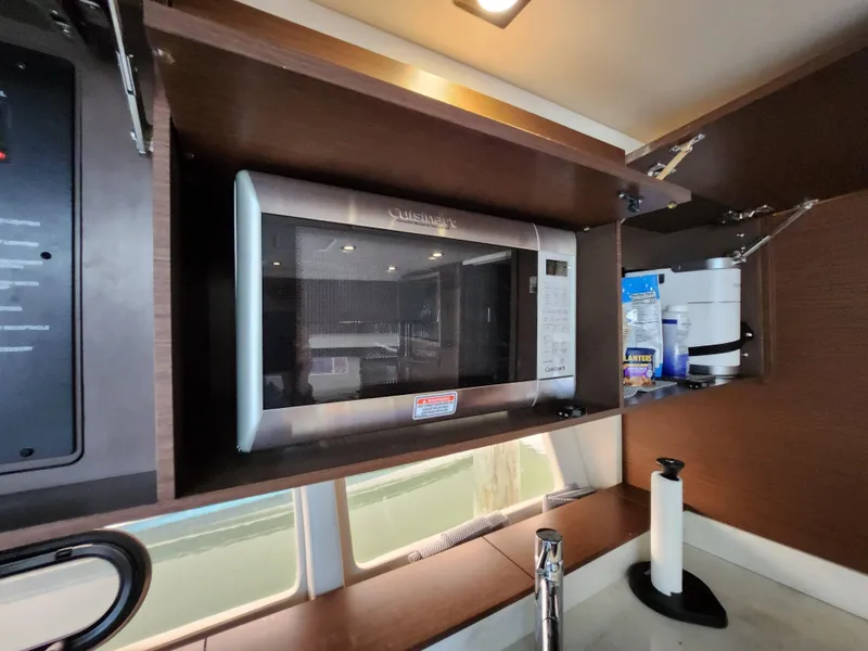Slide: The Image of 2014 Sea Ray 470 Sundancer kitchen with microwave and storage cabinets. - 37