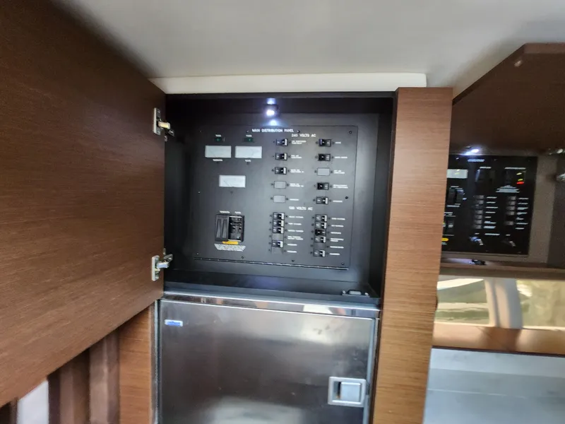 Slide: The Image of Electrical panel inside 2014 Sea Ray 470 Sundancer yacht, featuring modern wood cabinetry. - 38