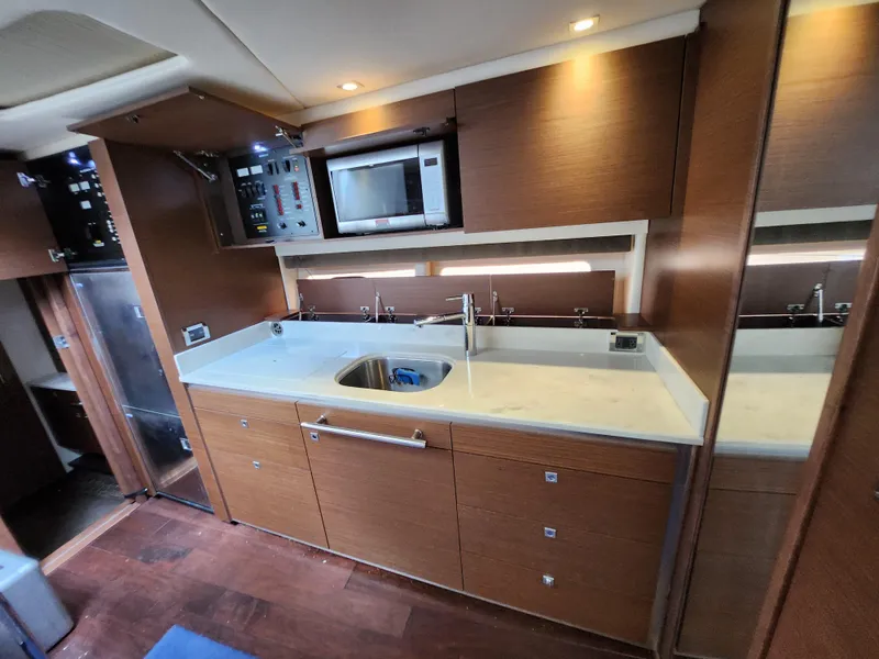 Slide: The Image of Modern kitchen interior of 2014 Sea Ray 470 Sundancer yacht with wood cabinetry and appliances. - 40