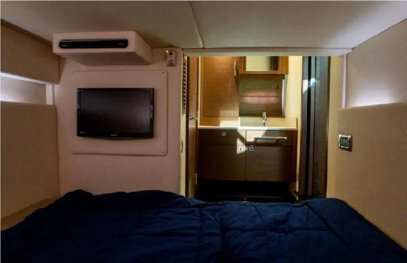 Slide: The Image of Interior cabin of 2014 Sea Ray 470 Sundancer with bed, TV, and bathroom. - 48