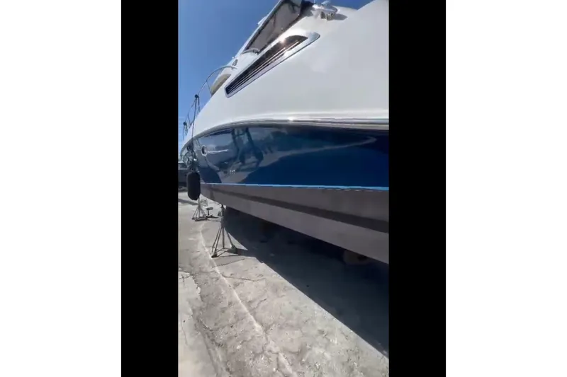 Slide: The Image of 2014 Sea Ray 470 Sundancer yacht on dry dock, side view under clear sky. - 67