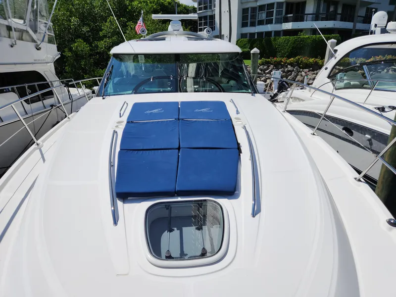 Slide: The Image of 2014 Sea Ray 470 Sundancer yacht with blue sun pads on deck, docked at marina. - 8