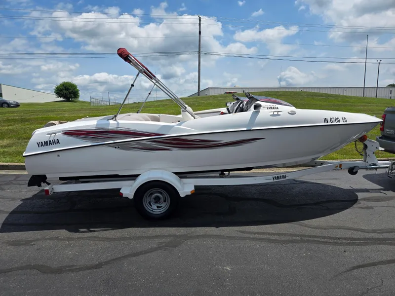 Slide: The Image of 2001 Yamaha LS 2000 boat on trailer, parked outdoors under a partly cloudy sky. - 4