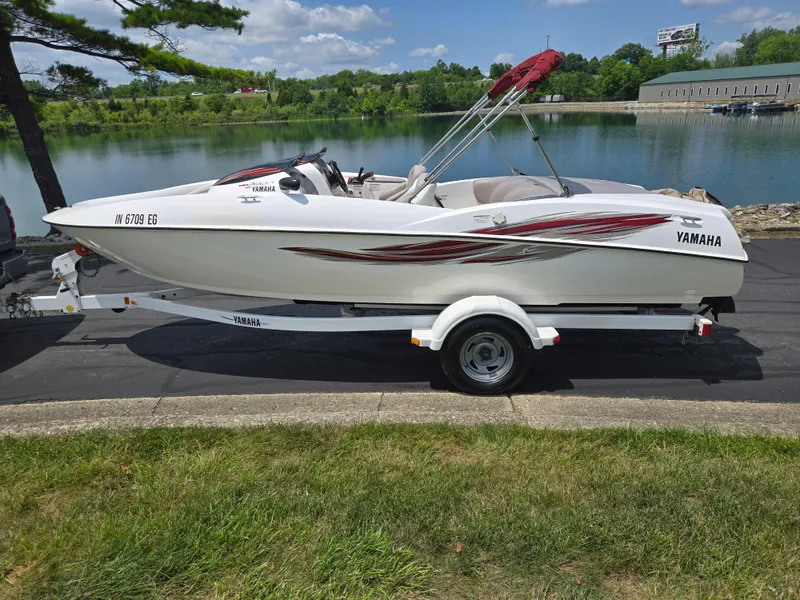 Slide: The Image of 2001 Yamaha LS 2000 boat on trailer by a lake, under clear blue sky. - 9