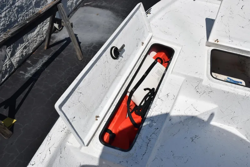 Slide: The Image of Open storage compartment on 2013 Blazer Bay 2170 boat, containing life jacket and rope. - 15