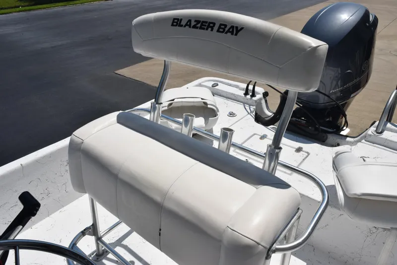 Slide: The Image of 2013 Blazer Bay 2170 boat with white seating and outboard motor. - 9