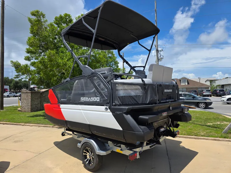Slide: The Image of 2025 Sea-Doo Switch Compact Sport boat on trailer, parked outdoors under a clear sky. - 6
