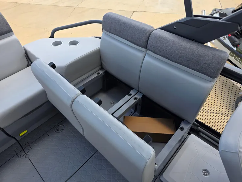 Slide: The Image of 2025 Sea-Doo Switch Compact Sport boat interior with open storage under gray seats. - 8