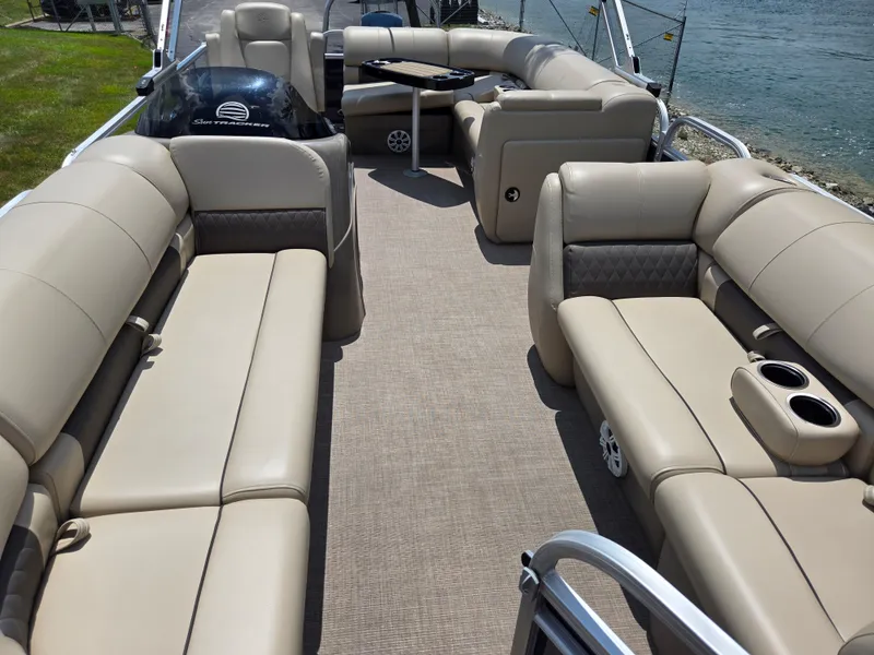 Slide: The Image of 2022 Sun Tracker Party Barge 20 DLX interior with beige seating and lake view. - 10