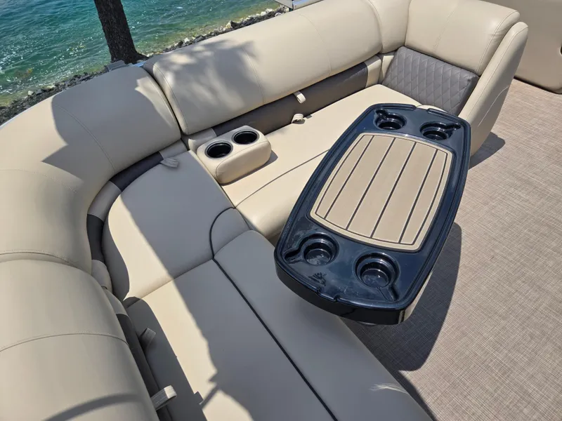 Slide: The Image of 2022 Sun Tracker Party Barge 20 DLX interior with beige seating and cup holders. - 15
