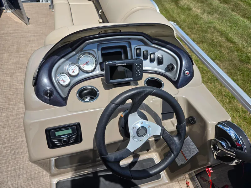 Slide: The Image of 2022 Sun Tracker Party Barge 20 DLX dashboard with steering wheel and control panel. - 17