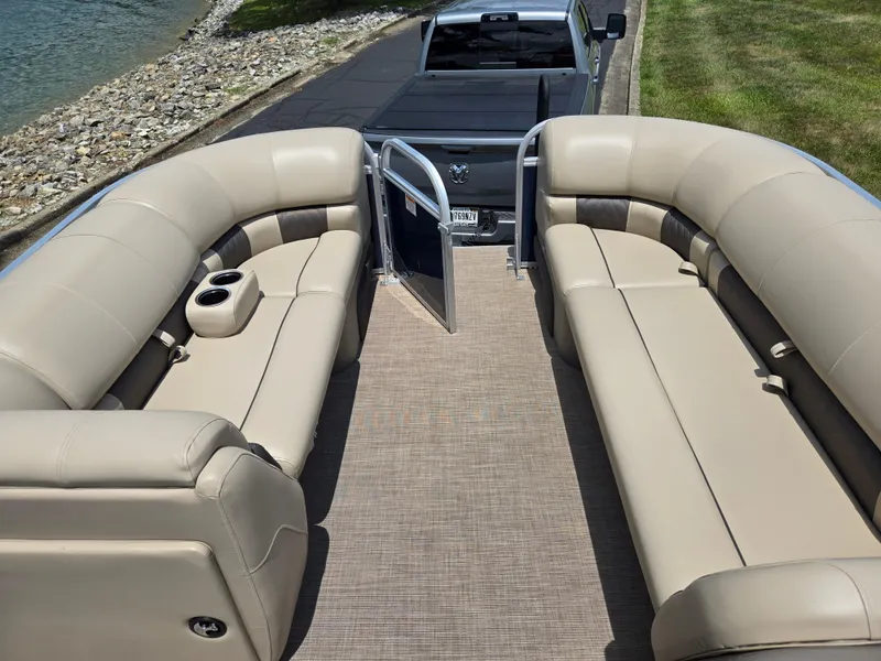 Slide: The Image of 2022 Sun Tracker Party Barge 20 DLX with beige seating, parked by a lakeside. - 19