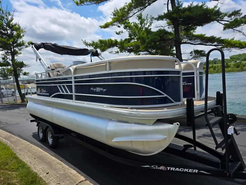 Slide: The Image of 2022 Sun Tracker Party Barge 20 DLX pontoon boat on trailer by a lake. - 8