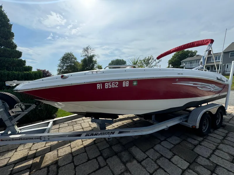 Slide: The Image of 2014 NauticStar 203SC Sport Deck boat on trailer, red and white design, parked outdoors. - 3