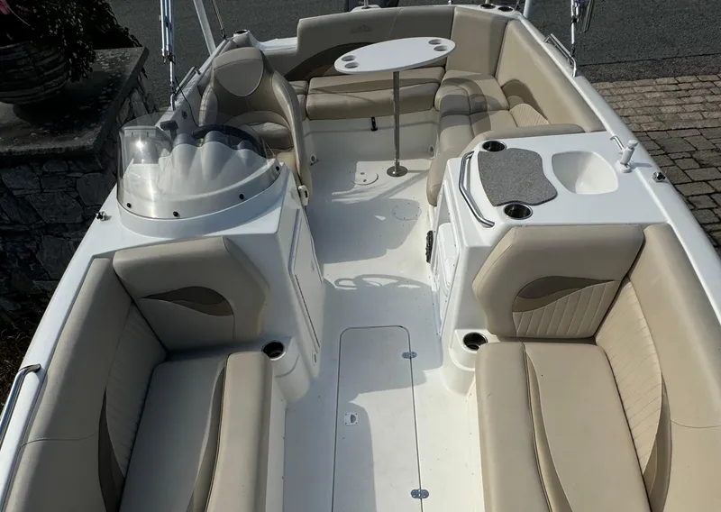Slide: The Image of 2014 NauticStar 203SC Sport Deck boat interior with beige seating and a central table. - 4